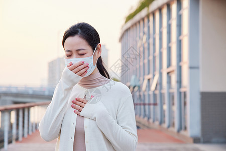 如何预防室外咳嗽戴口罩的青年女性背景