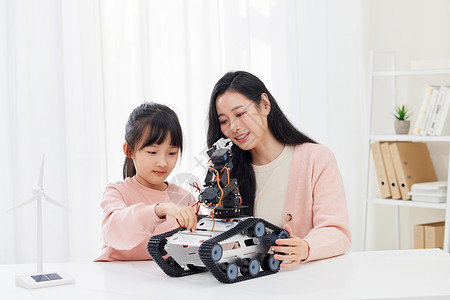 妈妈和女儿一起操作编程机器车高清图片