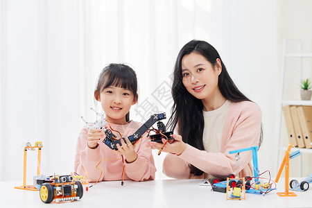 手拿机器人的小女孩与女老师图片