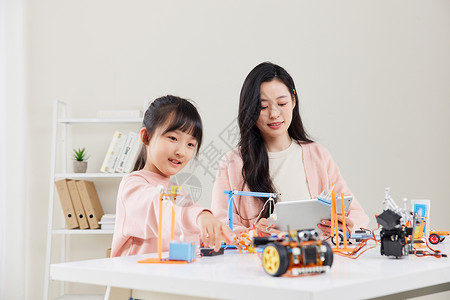 妈妈和女儿一起学习操作机器编程高清图片