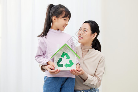 保护地球女孩妈妈和女儿手捧环保可回收标志背景