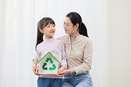 保护地球女孩妈妈和女儿手捧环保可回收标志背景