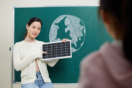 老师教小女孩太阳能板发电原理高清图片