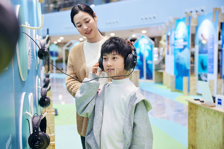 用耳机倾听大自然声音的母子图片