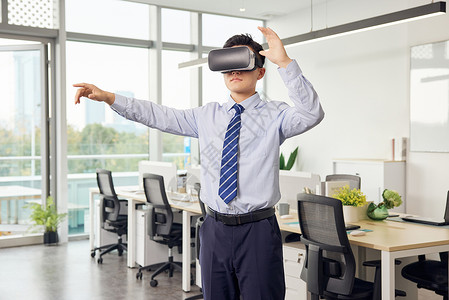 房产VR办公室里带着vr眼镜的男性操作虚拟屏幕背景