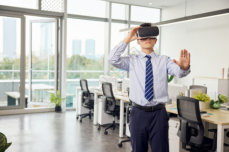 科技房办公室里带着vr眼镜的男性虚拟操作背景