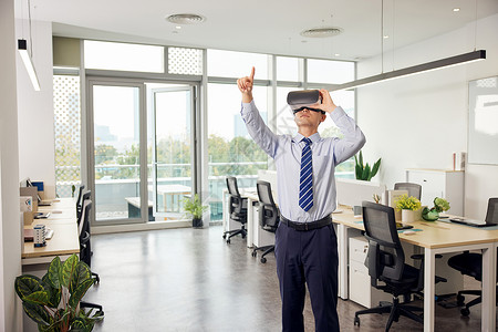 房产VR办公室里带着vr眼镜的男性操作虚拟屏幕背景