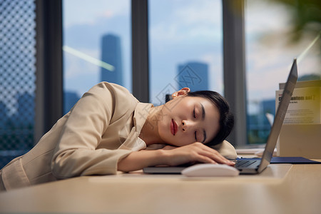 加班的职场女性在电脑旁睡着图片
