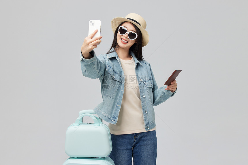 外出旅游的青年女子手拿护照自拍图片