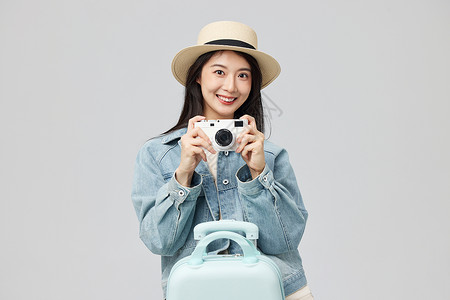 蓝色旅行箱相机拍照的年轻美女形象背景