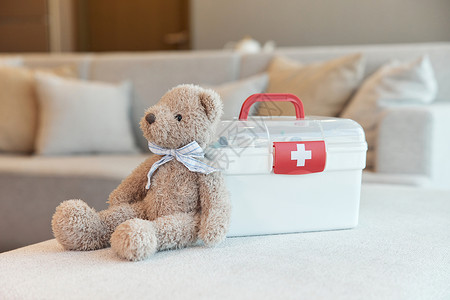 家用医疗箱和小熊玩偶背景