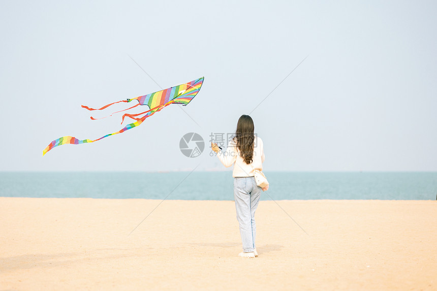在海边放风筝的女生背影图片
