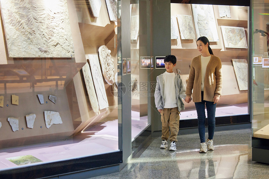 母亲和儿子走在博物馆长廊上图片