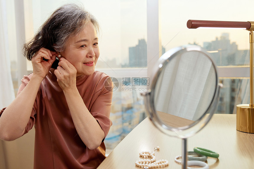 老奶奶对着镜子佩戴耳钉图片