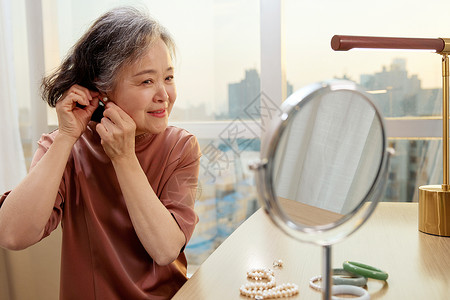 老奶奶对着镜子佩戴耳钉高清图片