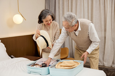 老年夫妻整理旅游衣物高清图片