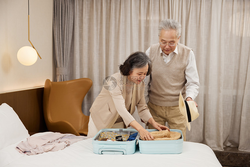 旅行的老年夫妻使用行李箱整理图片