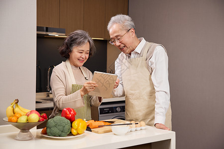 电脑菜单老年夫妻用平板电脑研究菜谱背景