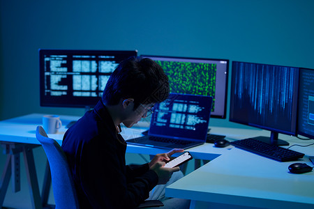 网络信息技术年轻男程序员工作间隙玩手机背景
