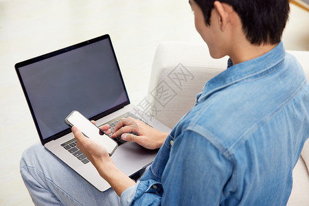 工作和家素材年轻男性使用笔记本电脑和手机背景