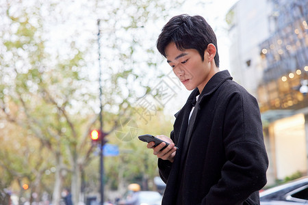 应用的年轻男性街头使用手机背景