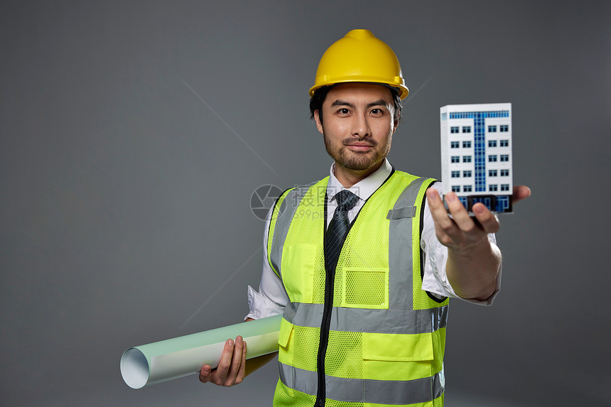 带安全帽的工人展示建筑模型图片