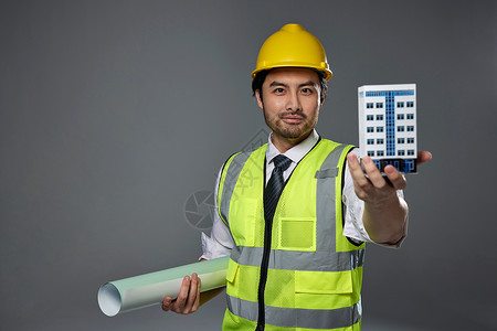 带安全帽的工人展示建筑模型高清图片