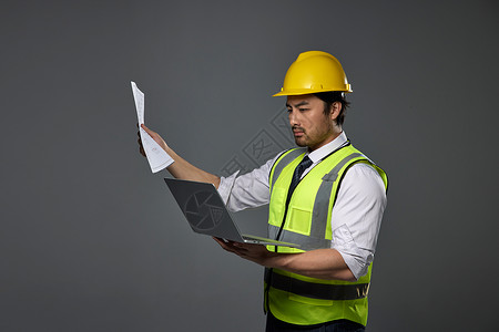 建筑工人核对电脑和图纸高清图片