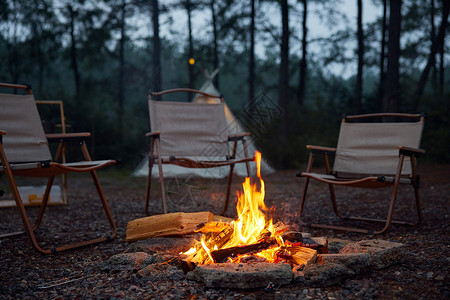 野营柴火堆露营椅和篝火背景