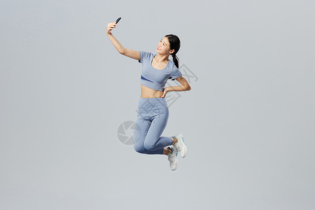创意健身女性使用手机自拍图片