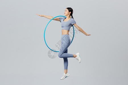 瑜伽圈创意健身女性手拿呼啦圈跳跃背景
