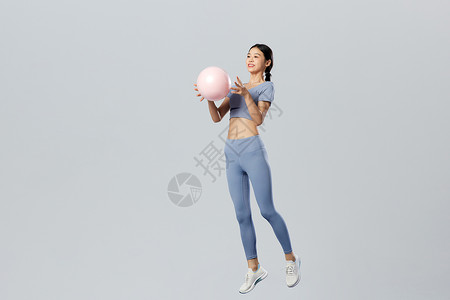 蓝色悬浮球创意悬浮女性手拿瑜伽球背景