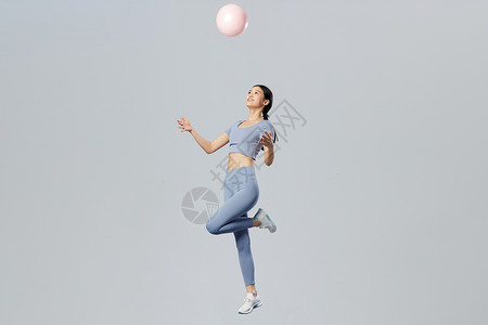 蓝色悬浮球创意健身女性空中抛球背景