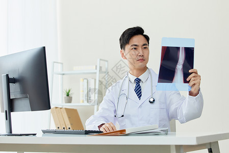 医生认真查看病人X光片图片