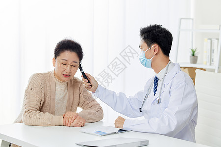 医生给中老年患者检测耳温图片