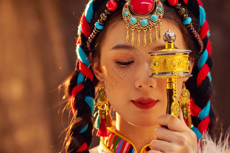 手拿经轮的藏族少女形象背景图片