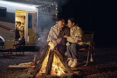 年轻夫妻户外露营篝火取暖图片