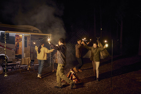 家庭露营围着篝火跳舞放烟花背景