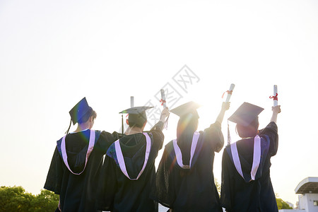 逆光鸟瞰大学生手举着毕业证背影背景