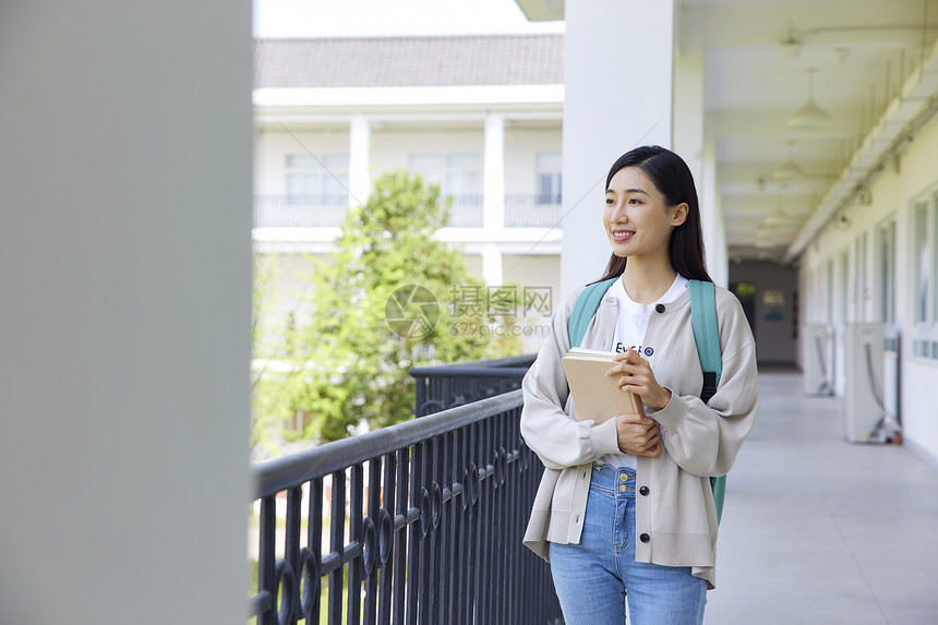 校园里手拿书本的女大学生图片