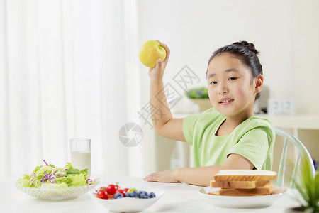 展示力量小女孩展示早餐苹果背景