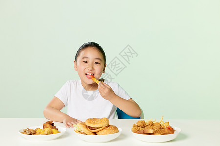 微胖小女孩吃高热量食品背景图片