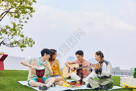 青年人户外野餐弹琴唱歌高清图片
