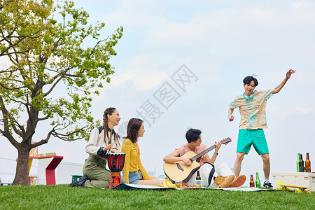 公园夏日野餐公园草地上年轻人聚会郊游背景