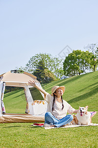 牵狗散步露营晒太阳的青年女性和宠物狗背景