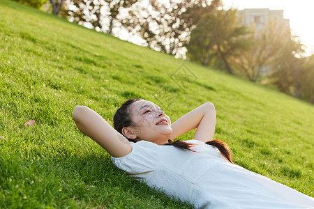 躺在草地上晒太阳的青年女子高清图片