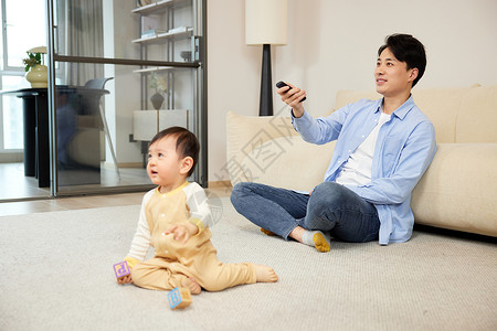 父亲与孩子在家看电视图片