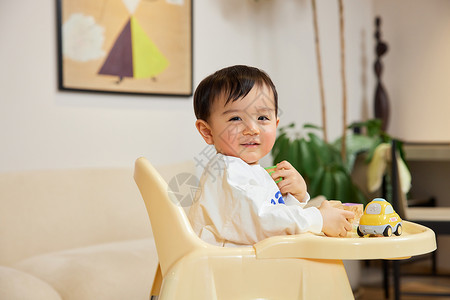 笑小孩坐在宝宝椅上开心笑的婴幼儿背景