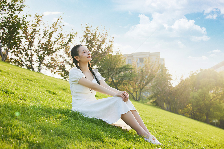 白裙少女坐在草地上图片
