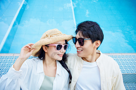 袋太阳镜情侣泳池边戴太阳镜的年轻情侣背景